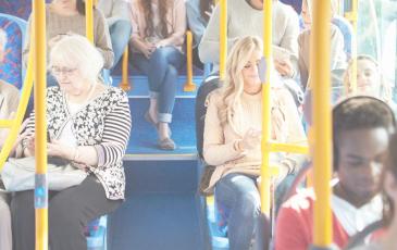 Image shows people sitting on a London bus 